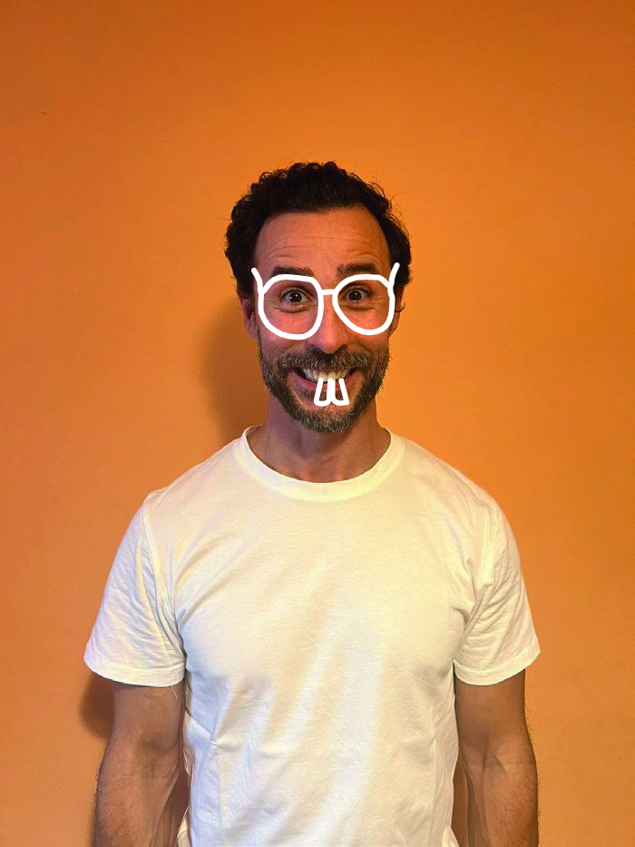 Retrato de Telmo Ramalho, de t-shirt branca, sobre fundo cor de laranja